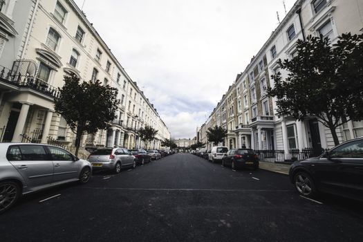 Classic architecture and parked cars line a serene urban residential street.