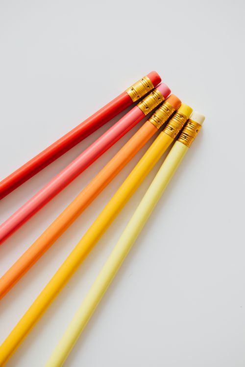 Free Vibrant colored pencils aligned on a white surface, perfect for stationery themes. Stock Photo