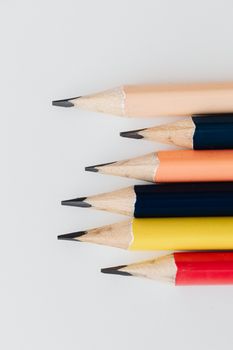 Close-up of colorful pencils arranged in a vertical pattern on a white background.