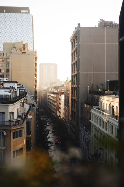 City street with modern high buildings on both sides of road and hiding in haze in distance on daytime