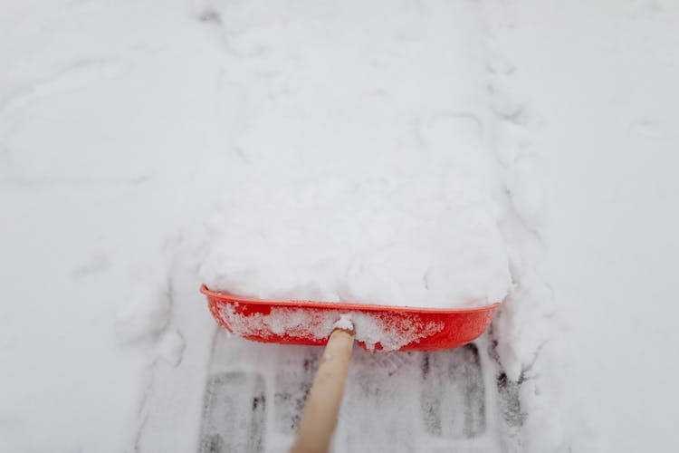 A Person Removing Snow With A Shovel