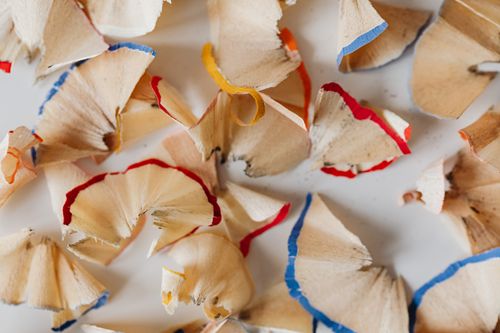 Free Close-up photo of colorful pencil shavings scattered on a white surface. Stock Photo