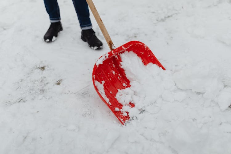 Close-up Of Person Shoveling Snow Outdoors