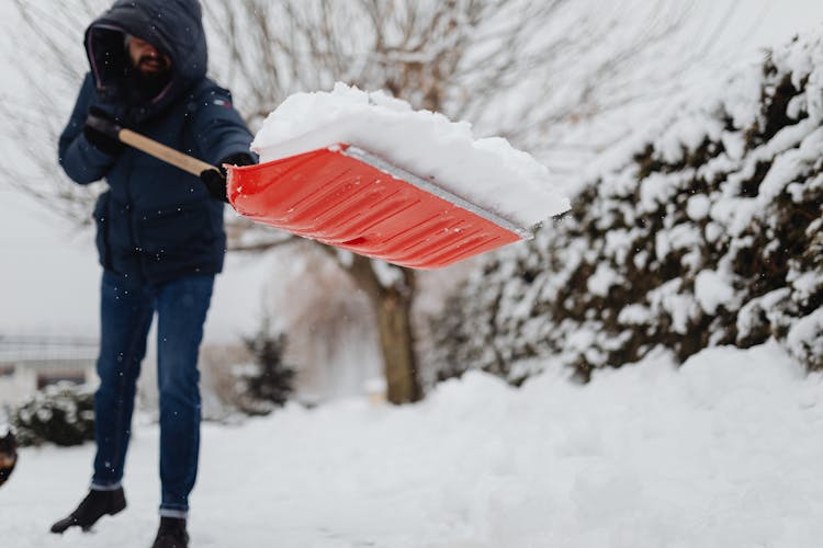 A Man Using A Shovel To Remove Snow