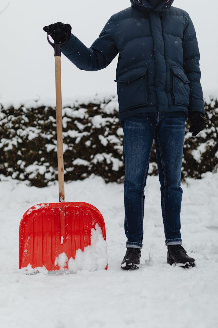 A Person Holding A Snow Shovel