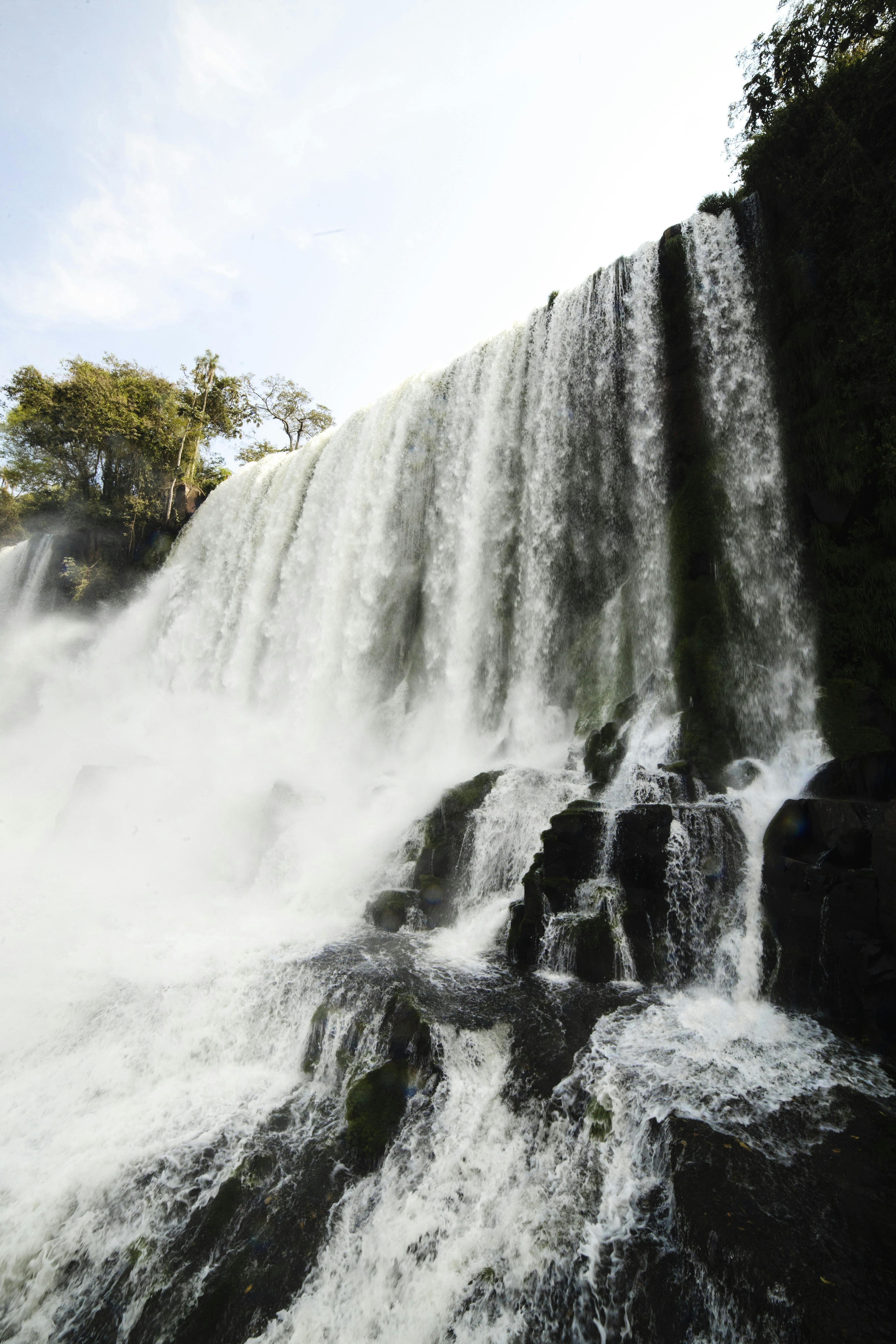 郁郁葱葱的树叶环绕着瀑布下令人叹为观止的岩石悬崖，捕捉了大自然的能量