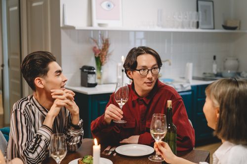 Free A group of friends enjoying an indoor gathering with wine, laughter, and conversation. Stock Photo