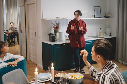 A group of friends enjoying a lively dinner discussion in a stylish, modern kitchen setting.