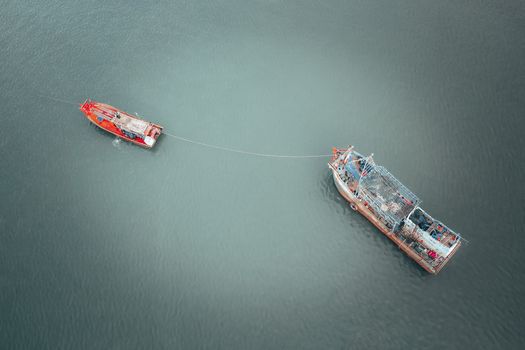 Fishing boats connected with rope on river