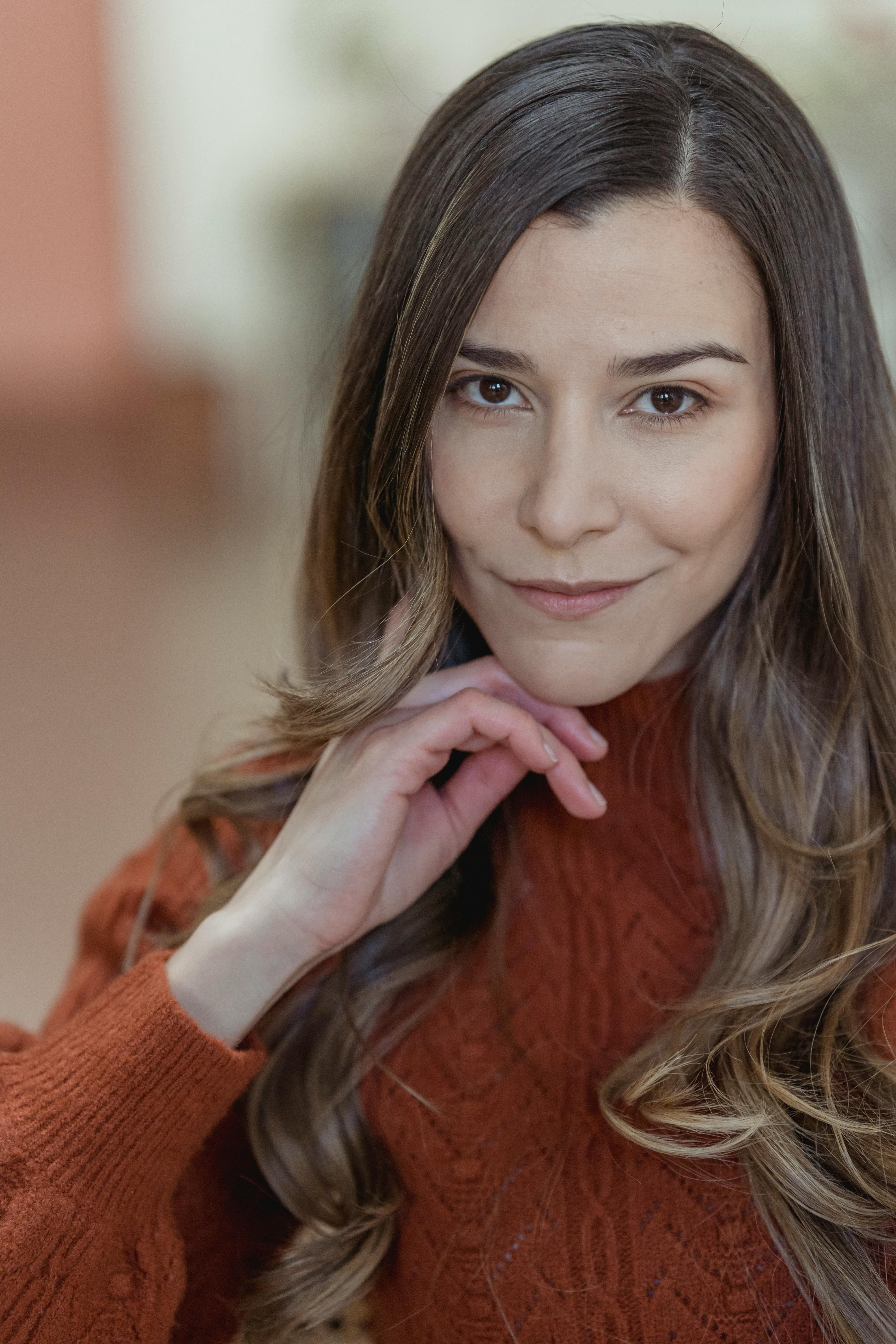 Attractive positive woman touching face and looking at camera