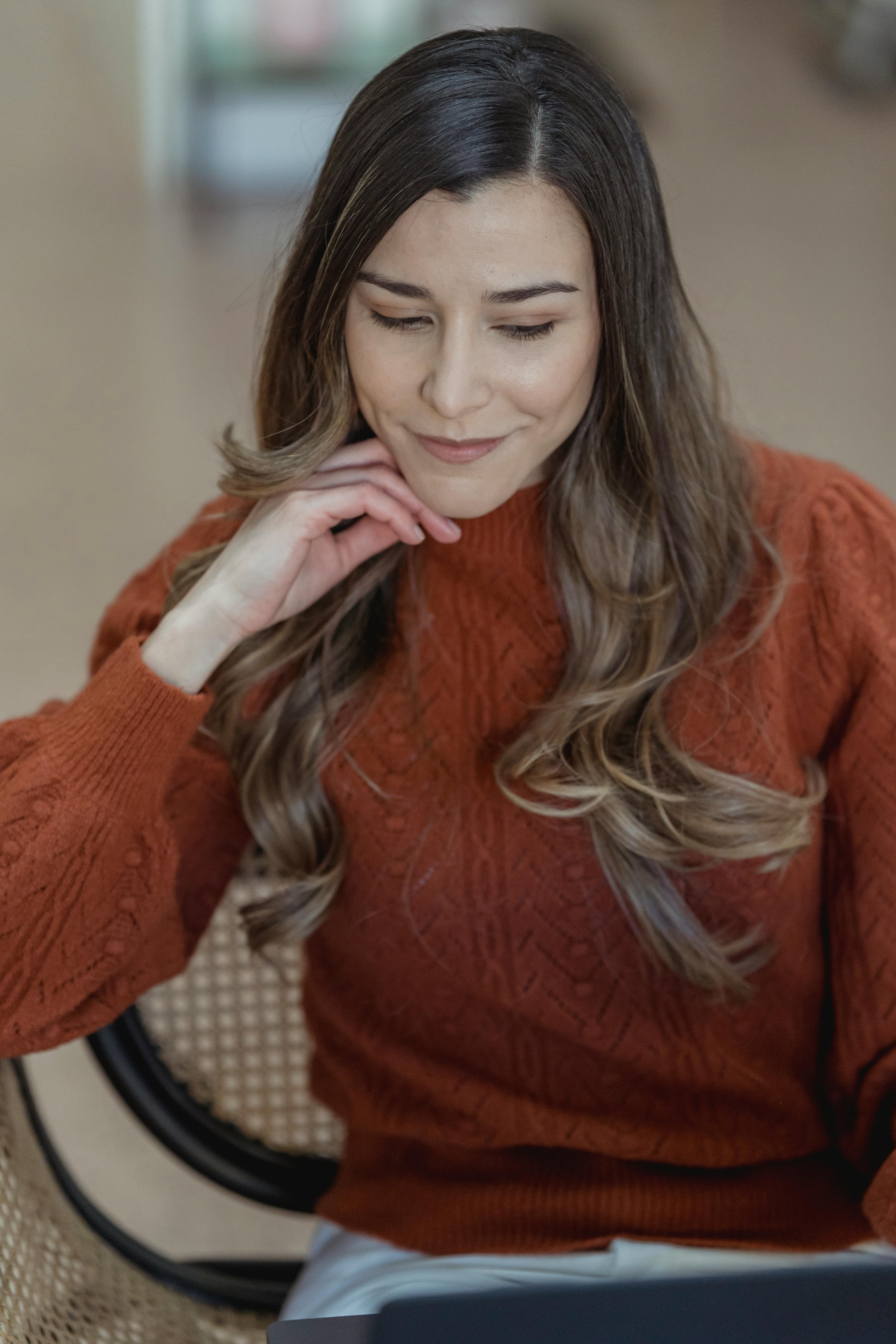 smiling woman working on laptop while sitting on chair