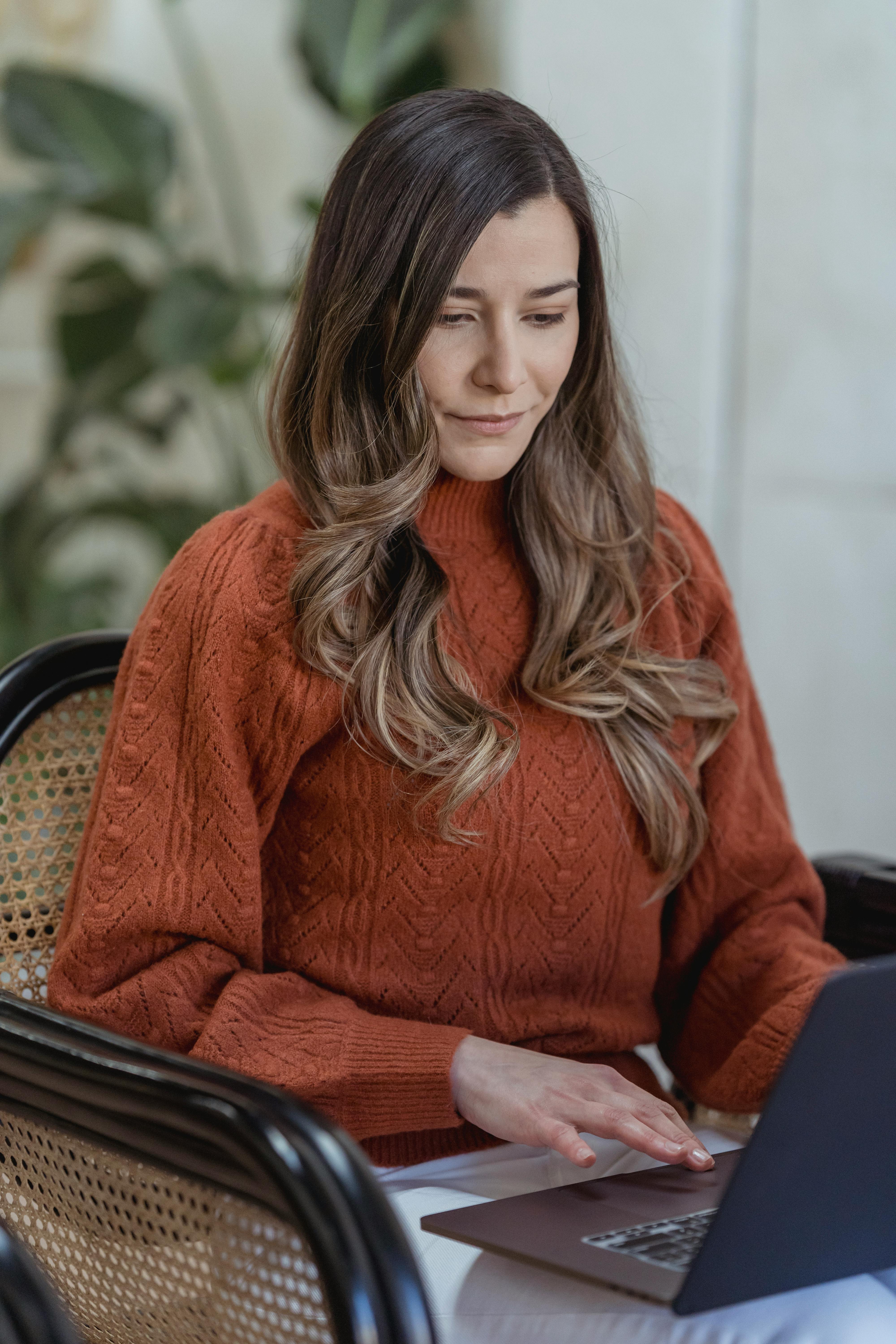 focused freelancer working on laptop in chair