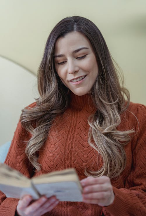 Smiling woman reading book in free time