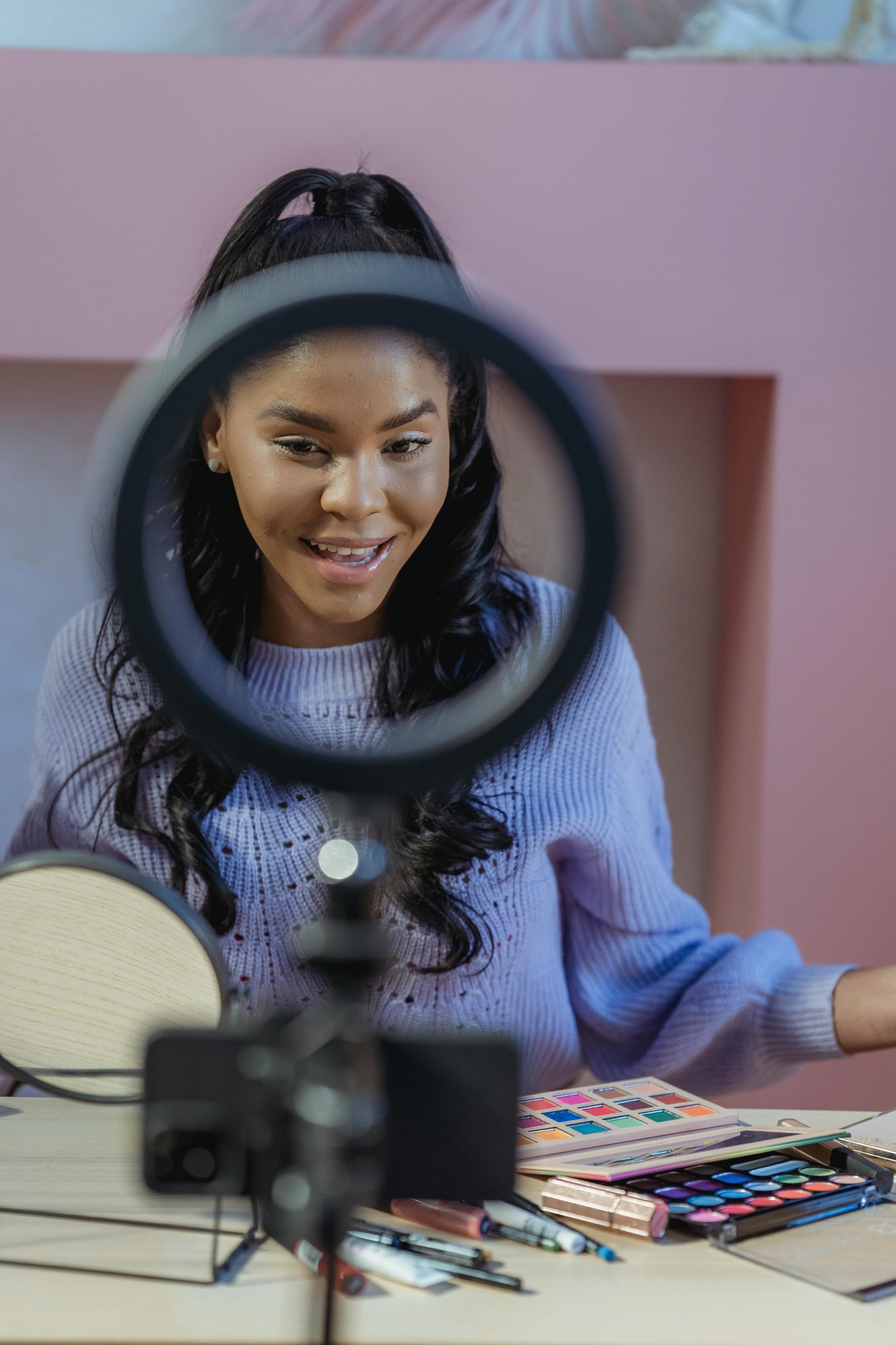 a makeup artist in a purple turtleneck.