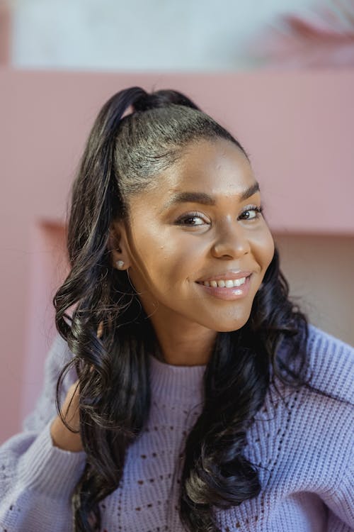 Smiling black woman touching wavy hair