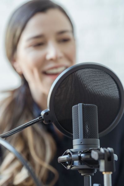 Host talking into a studio mic — George Milton on Pexels