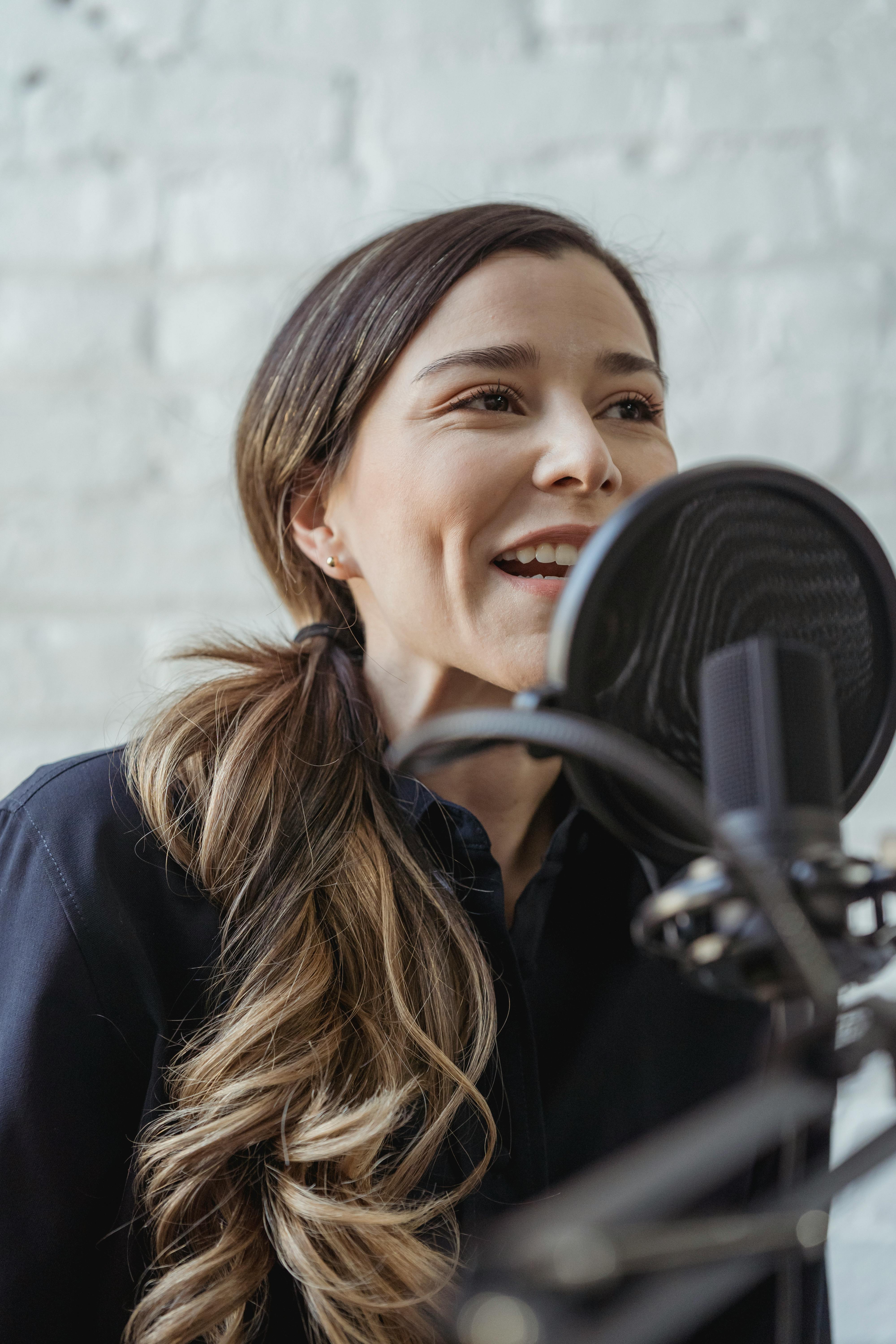 happy woman talking while recording podcast in studio