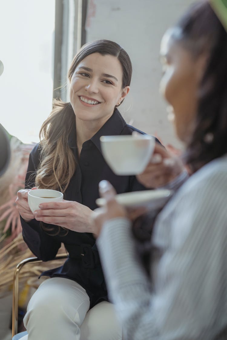 Positive Diverse Friends Talking And Having Cup Of Coffee