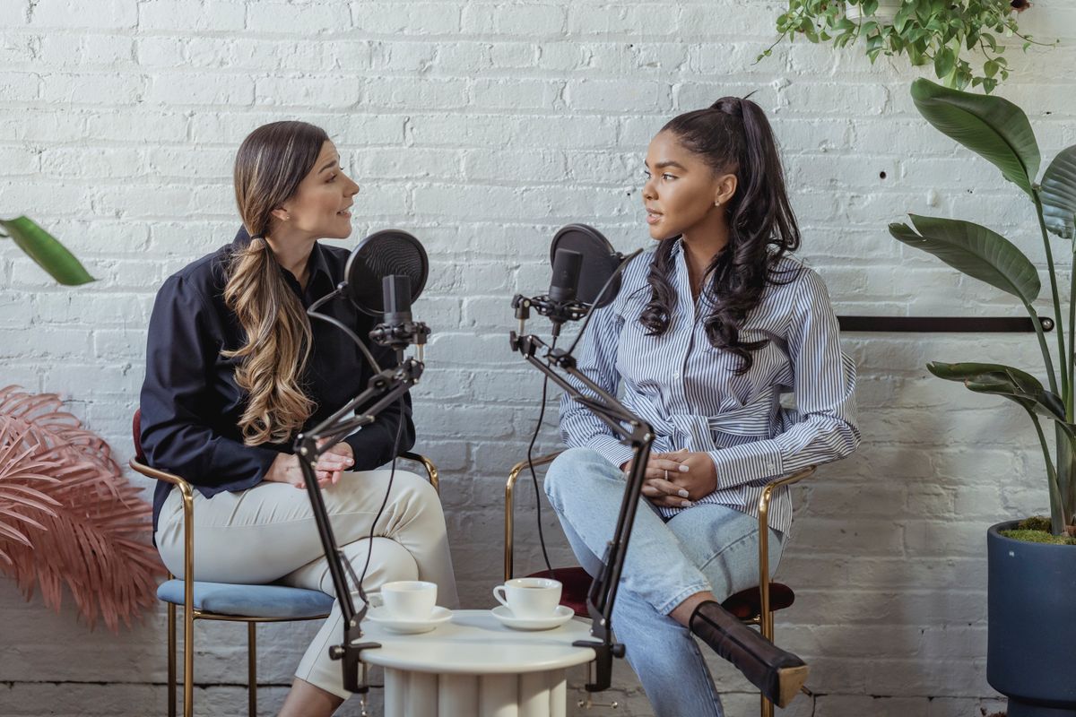 Two women talking into studio microphones during an interview