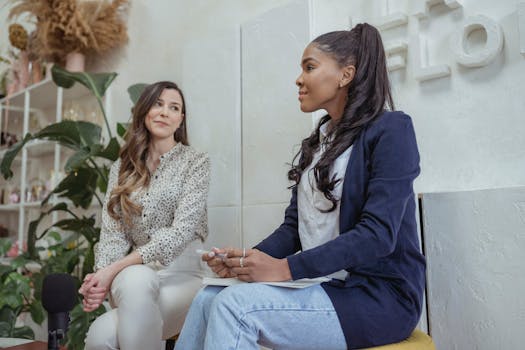 Two businesswomen engaged in a professional discussion in a modern office interior.