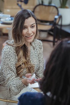 Two women engaging in a friendly discussion at a modern workspace.