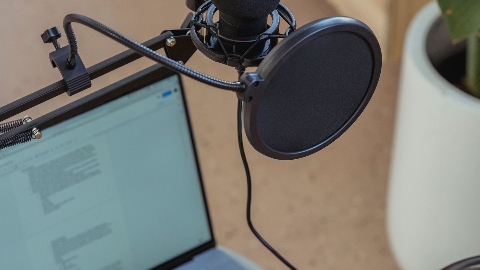 Mikrofon i laptop w stanowisku do produkcji własnych materiałów audio i medialnych