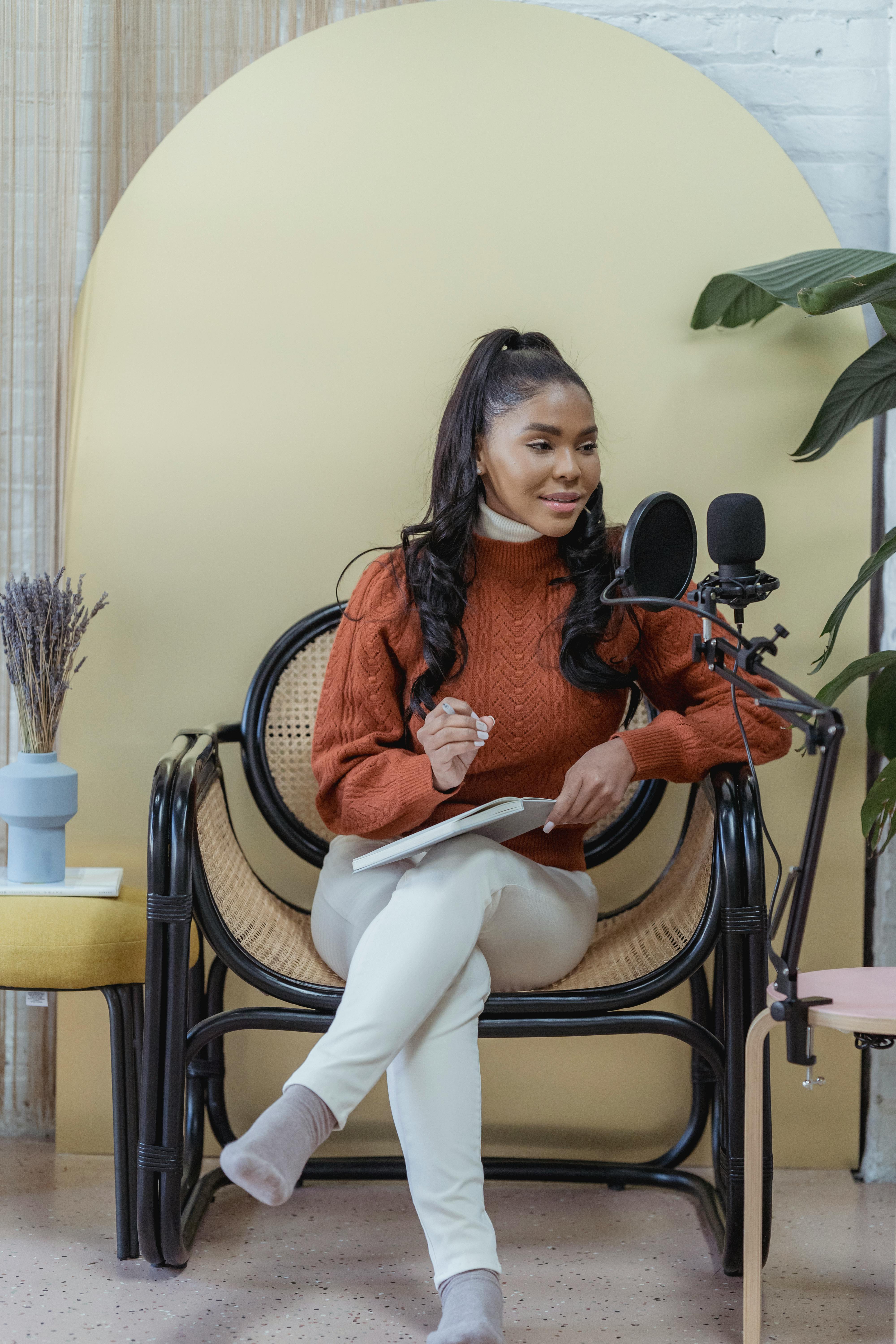 positive ethnic female podcaster speaking into microphone