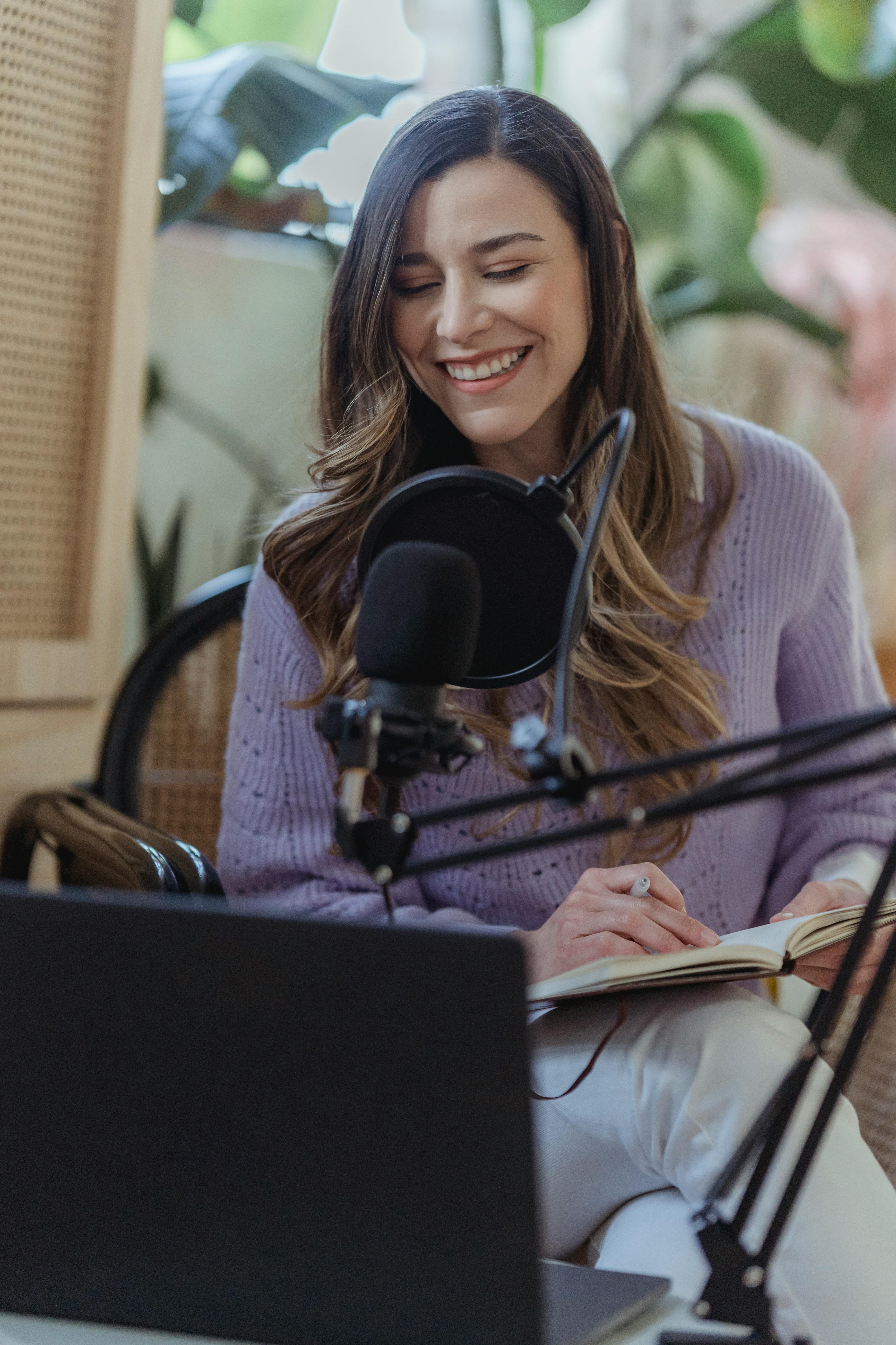 smiling woman recording voice podcast in microphone