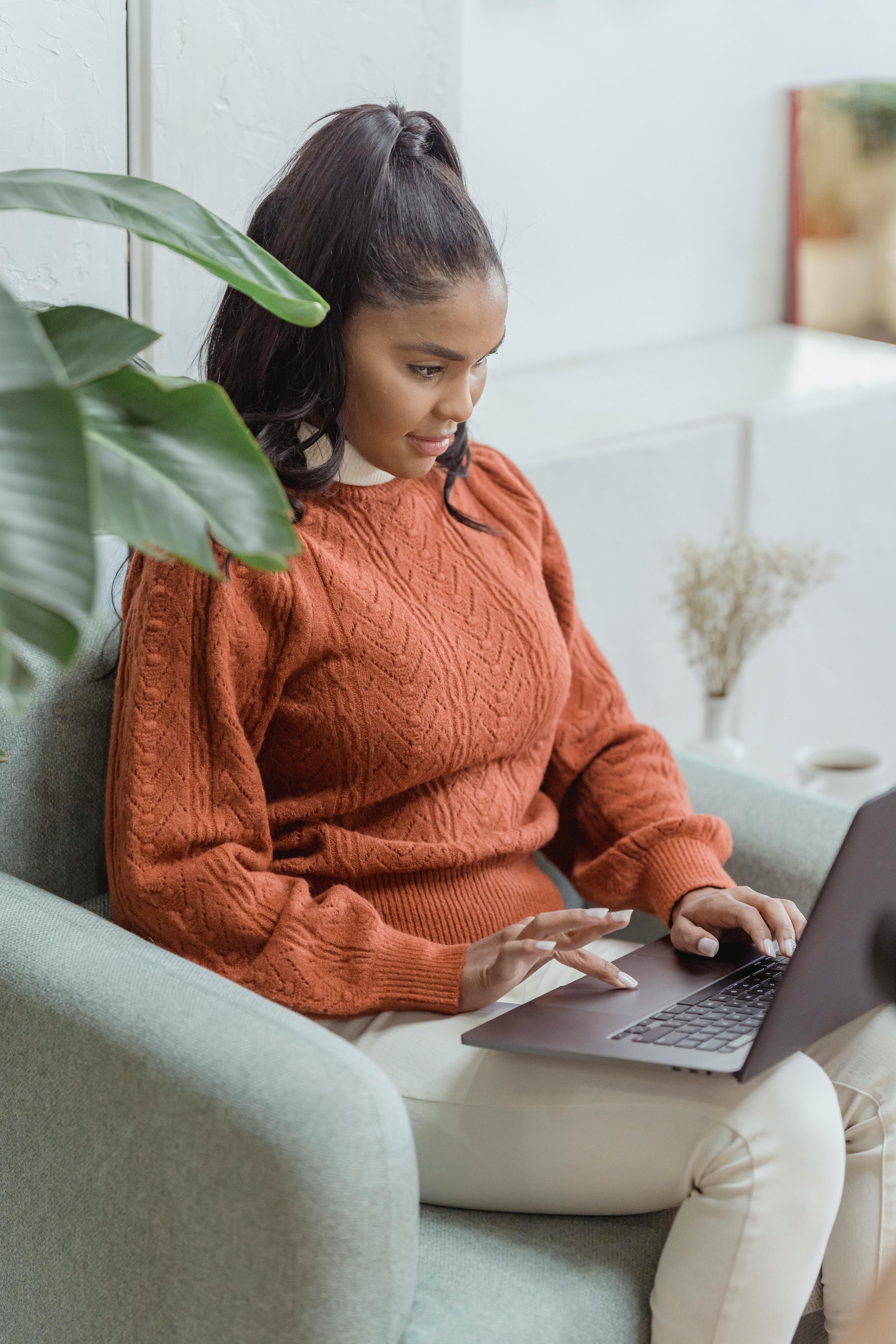 focused black female freelancer doing online work on laptop