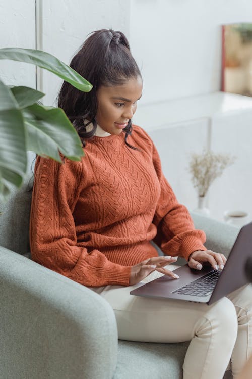 Free Focused black female freelancer doing online work on laptop Stock Photo