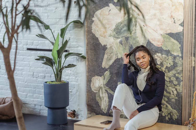 Stylish Young Black Woman Enjoying Song In Earphones In Modern Apartment