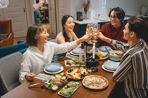 Free People Sitting Around the Table Doing Cheers  Stock Photo