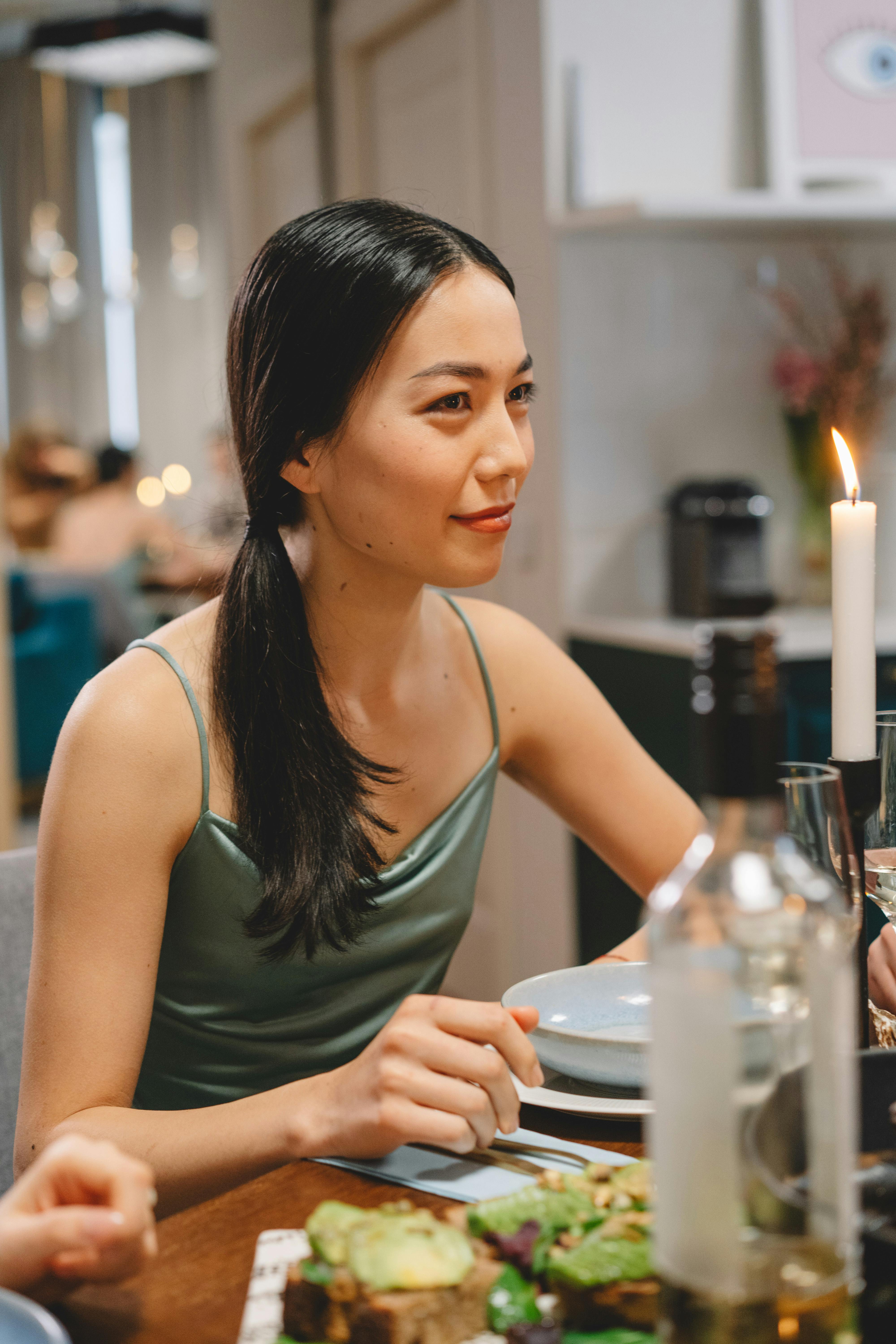 Free Woman in a Green Top Near a White Candle Stock Photo
