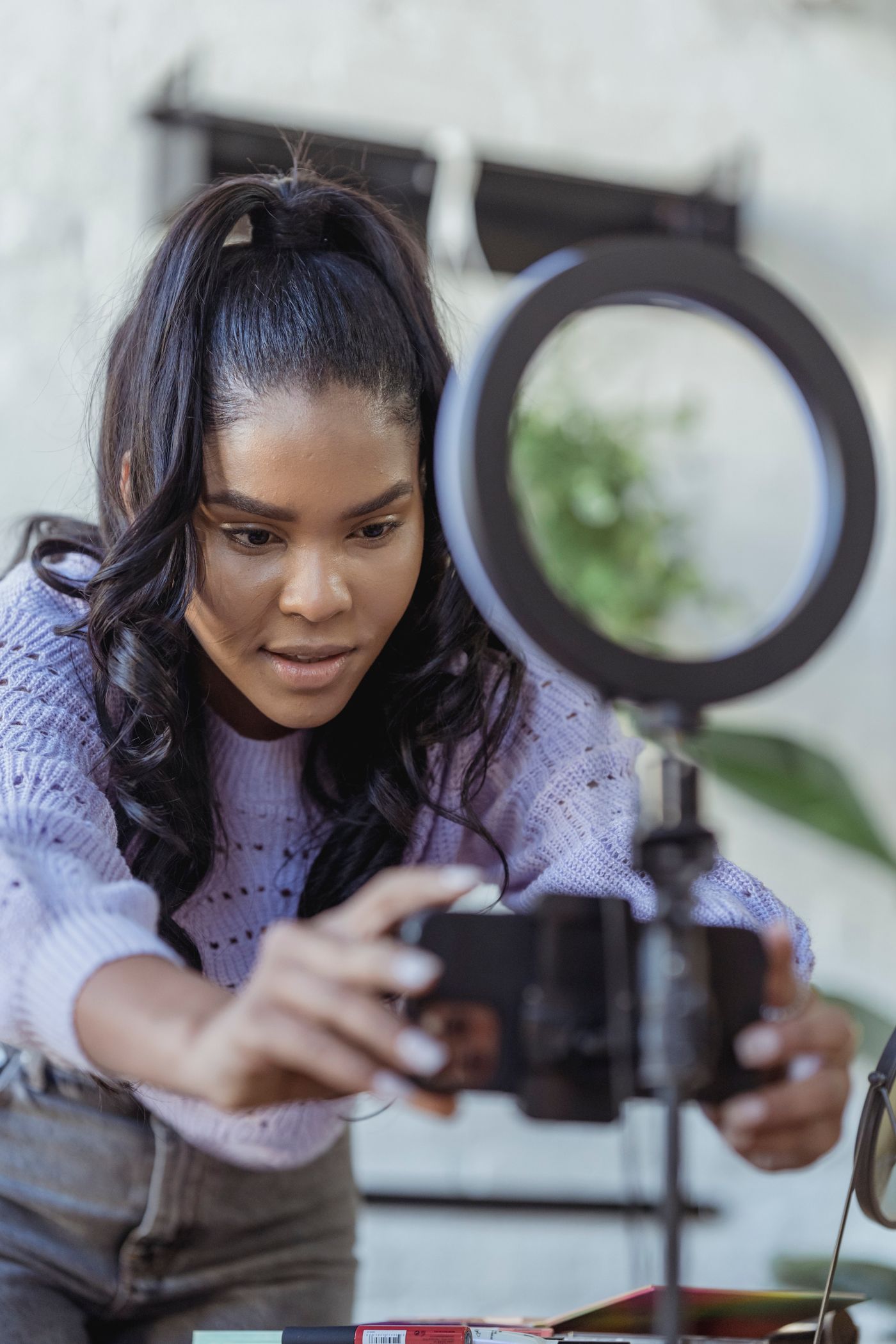 Creator preparing a smartphone and ring light for a video shoot