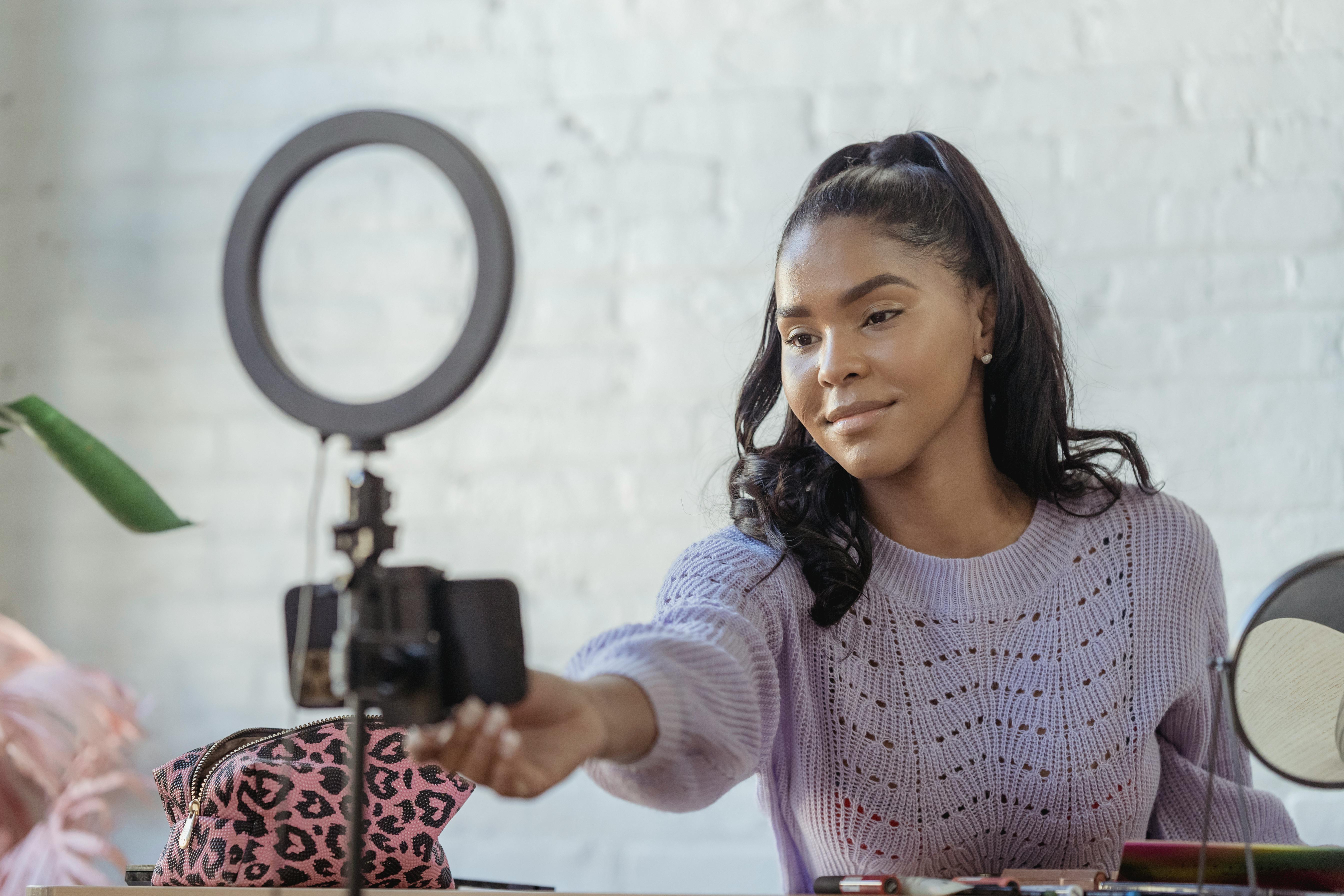 happy black woman preparing for online recording with smartphone