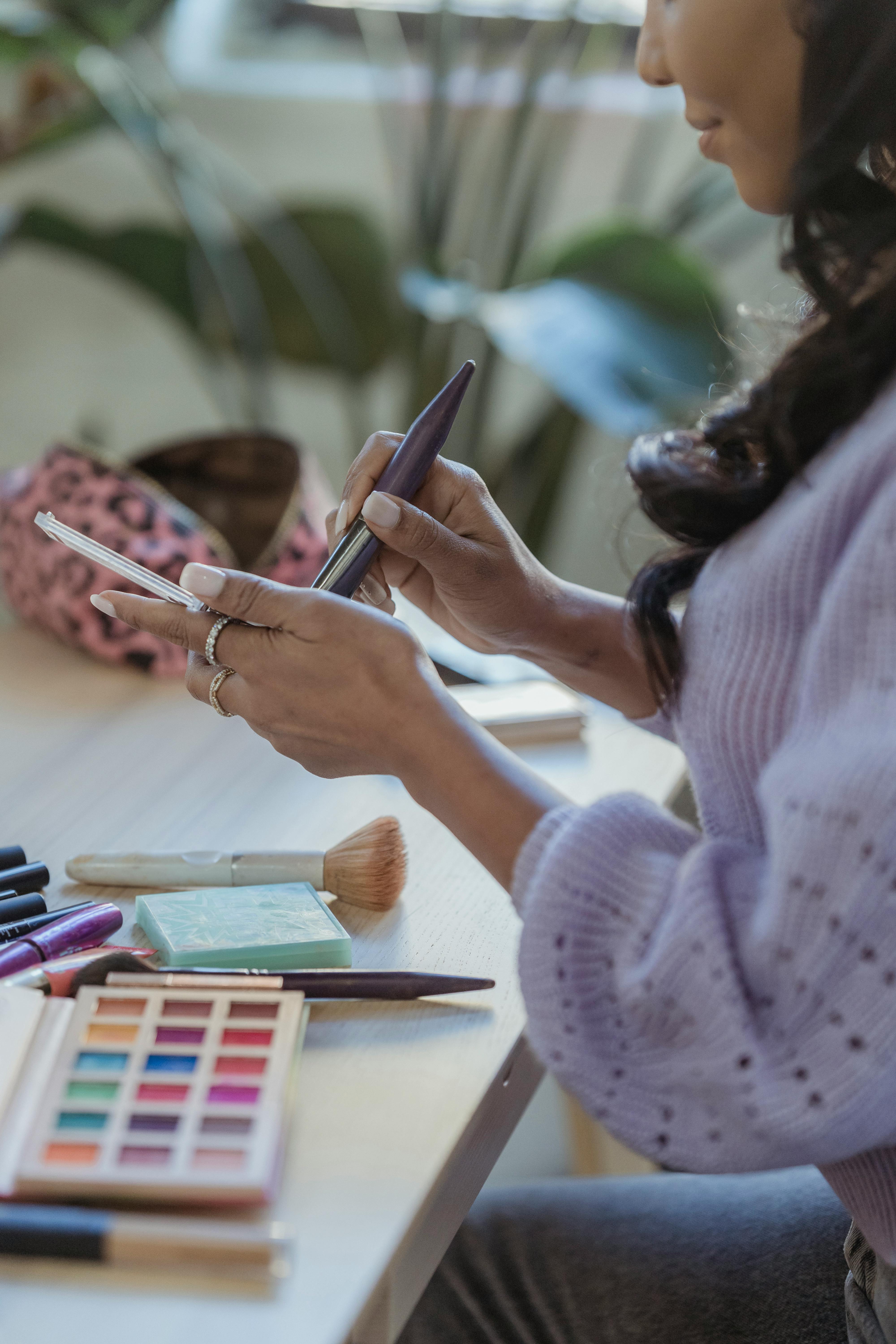 black woman taking powder from palette with brush