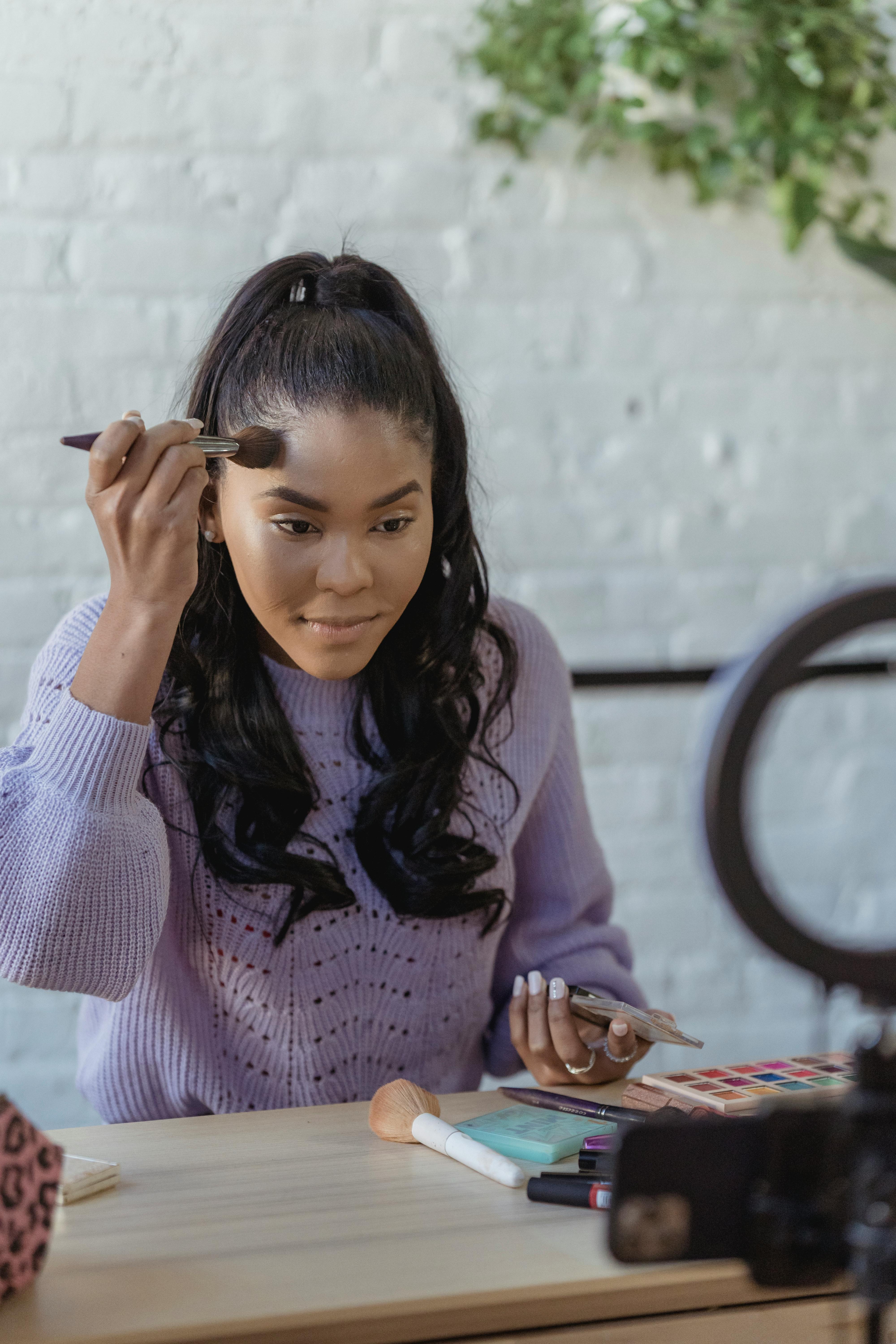 black professional visagiste applying foundation on forehead