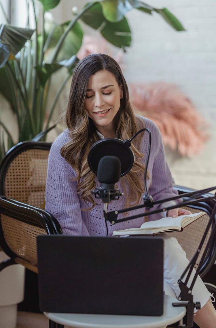 Smiling Woman Recording Podcast On Microphone With Laptop