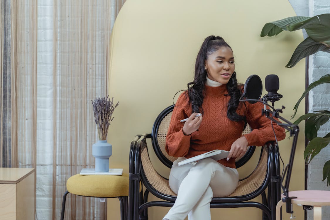 Free Cheerful black woman recording audio podcast Stock Photo