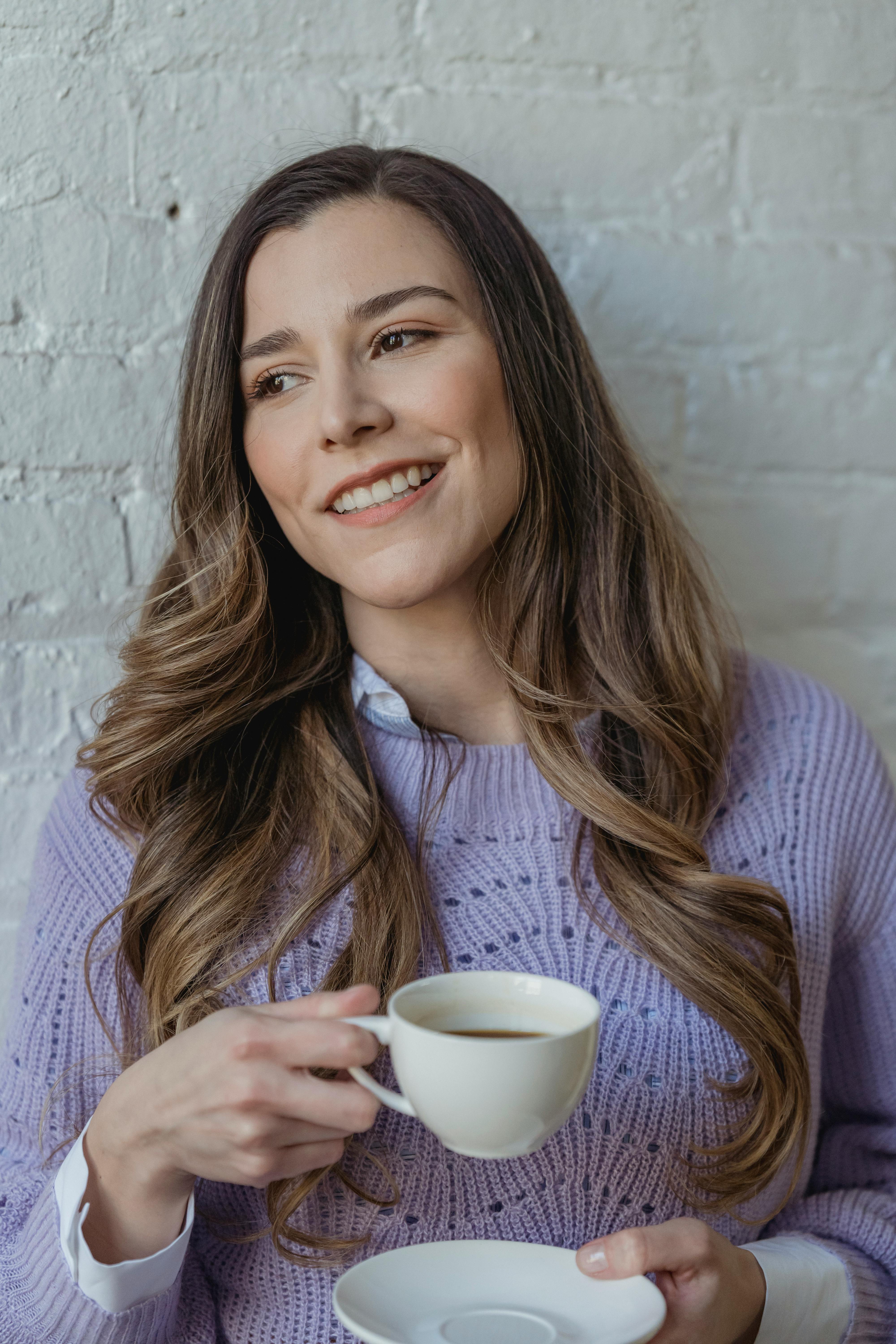 cheerful woman with coffee at wall