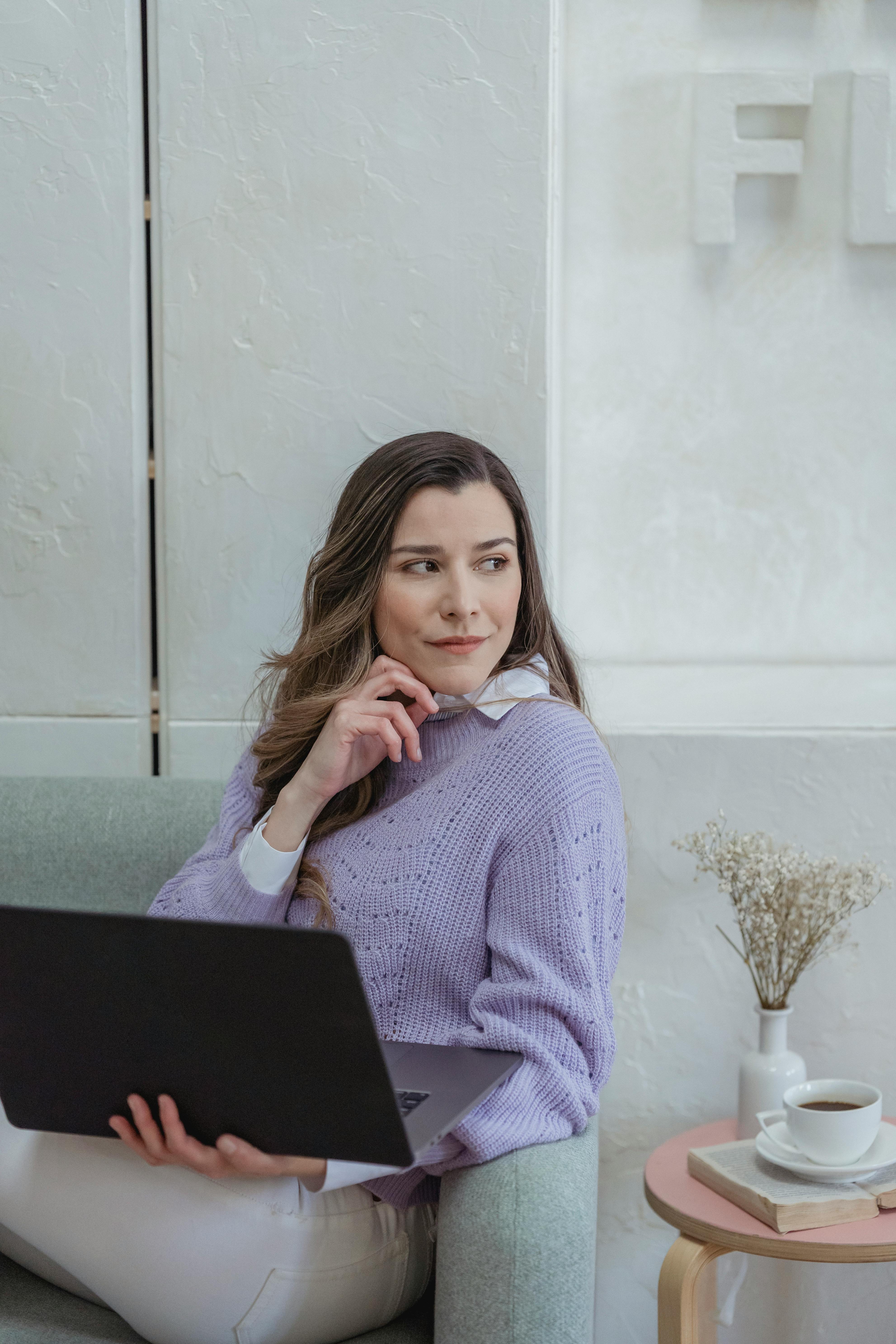 glad woman with laptop sitting on couch