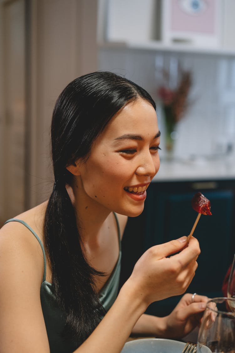 Portrait Of A Woman Holding A Stick With Food