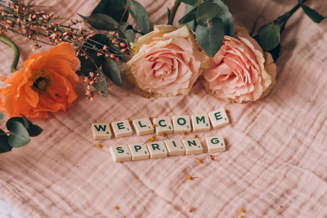 Scrabble Tiles Beside Blooming Roses