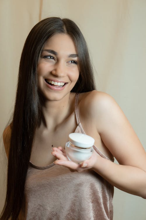 A Woman Holding a Bottle of Cream