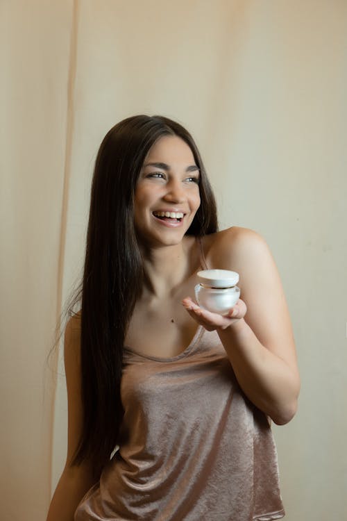 Photo of a Woman Smiling with a Product on Her Hand