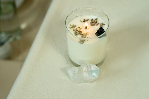 Free Lit aromatherapy candle with herbs and crystals for relaxation and healing. Stock Photo