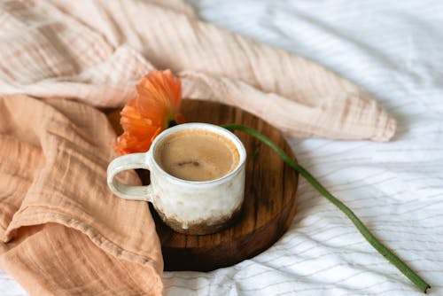 A Cup of Coffee Near an Orange Poppy Flower