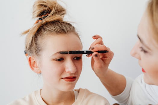 Close-up of a young girl having her eyebrows done with makeup by a woman. Perfect for beauty and lifestyle themes.