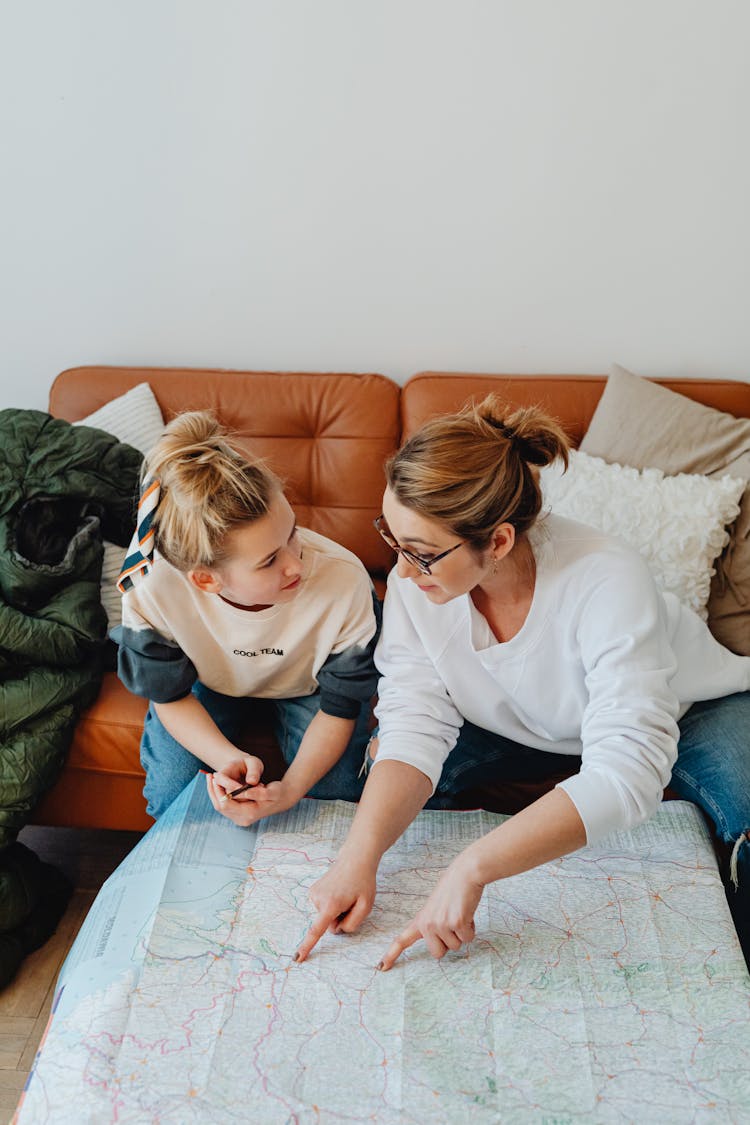 A Mother Talking To Her Daughter While Pointing At A Map