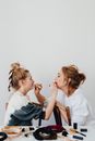 Photo of a Mother and Daughter Applying Lipstick on Each Other